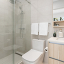 Ensuite bathroom at Avenue 33 by Vertex Developments featuring a stand-up shower with modern Alt by AQUABRASS rainshower and hand shower, solid surface quartz countertops, porcelain tile flooring, one-piece dual flush DURAVIT toilet, and mirrored medicine cabinet with adjacent storage.