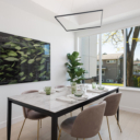 Dining room at Avenue 33 by Vertex Developments featuring a 3-panel double-glazed aluminum frame exterior window for energy efficiency and engineered wide plank hardwood flooring, with staged furniture.